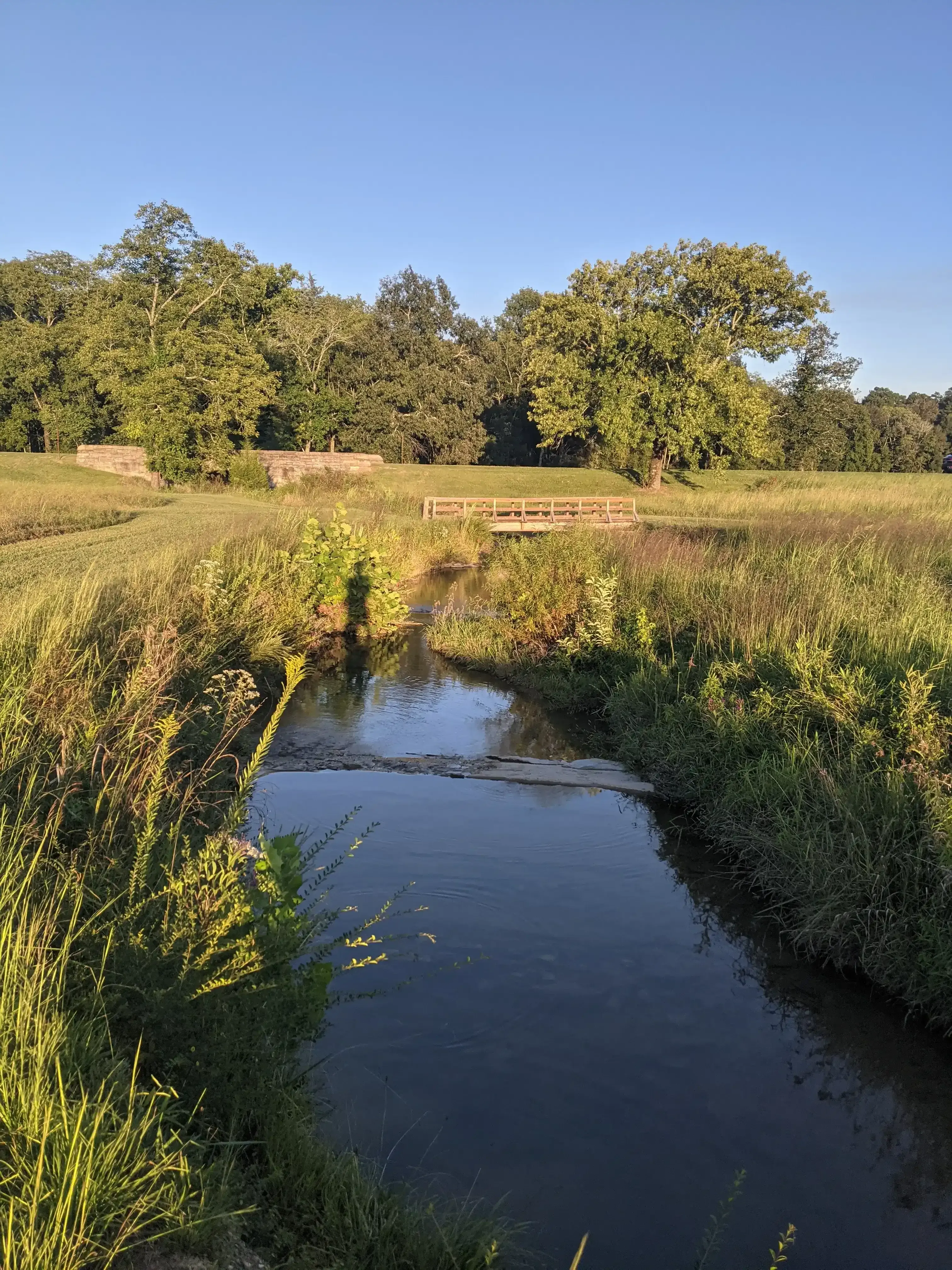 A Chickamauga Battlefield landscape photo of a bridge, creek and a worn in walking trail.